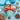 Heart-shaped Boooja-Booja Chocolate Salted Caramel chocolate box with hand-painted floral design and a red ribbon, on a blue background surrounded by ribbon, ingredients and chocolate truffle hearts.